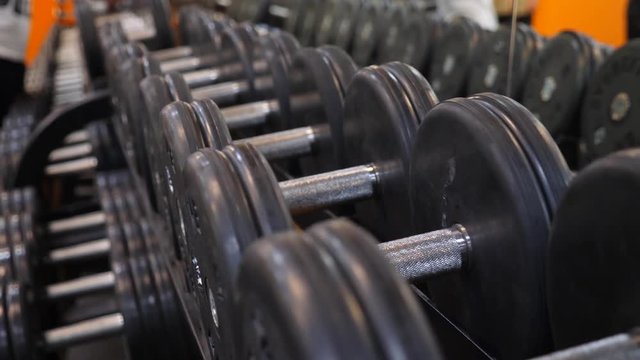 dumbbells lying in a row in the gym. 4k. Slow motion