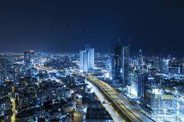 Fototapeta na wymiar Tel Aviv Skyline At Night, Skyscraper and Ayalon Freeway - Toned In Blue