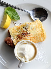 Close-up of a plated chocolate pancake served with ice-cream on a white plate