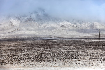 Large mountains covered with snow and fog