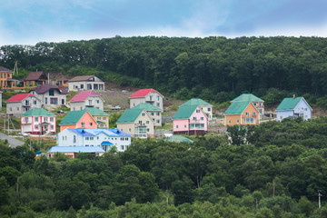 Small cottages near green trees.