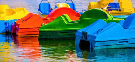 Fototapeta na wymiar Abstract colored shot of pedal boats with reflections in water