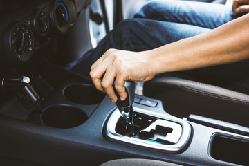 Woman hand changing gear while driving scene