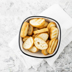 Fresh crunchy homemade toast from the baguette for home lunch or snack, for making sandwiches, for soups and snacks. Top view. On a light marble background.