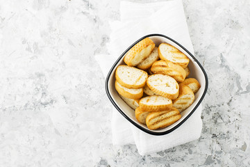 Fresh crunchy homemade toast from the baguette for home lunch or snack, for making sandwiches, for soups and snacks. Top view. On a light marble background.