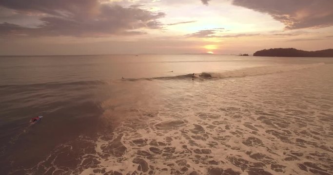 Surfing Waves at Sunset on Tropical Beach in Thailand, Aerial Drone Shot
