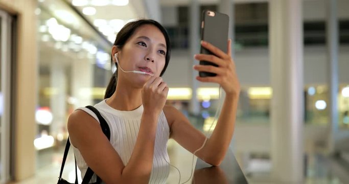 Woman making video call on cellphone in shopping center