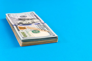 Stack of american dollar bills on the blue background.
