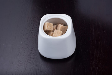 brown sugar in bowl on black background