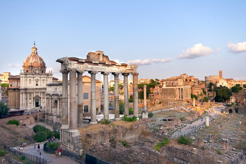 Fototapeta premium Rome, Italy. Ruins of the Roman Forum, with temple of Saturn, at sunset. Famous historical landmark in Europe.