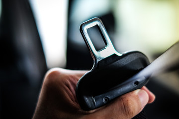 Hand of driver holding seat belt (safety belt) lock in car before driving - safety & secure concept.