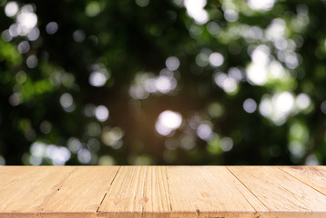 Image of dark wooden table in front of abstract blurred background of outdoor garden lights. can be used for display or montage your products.Mock up for display of product