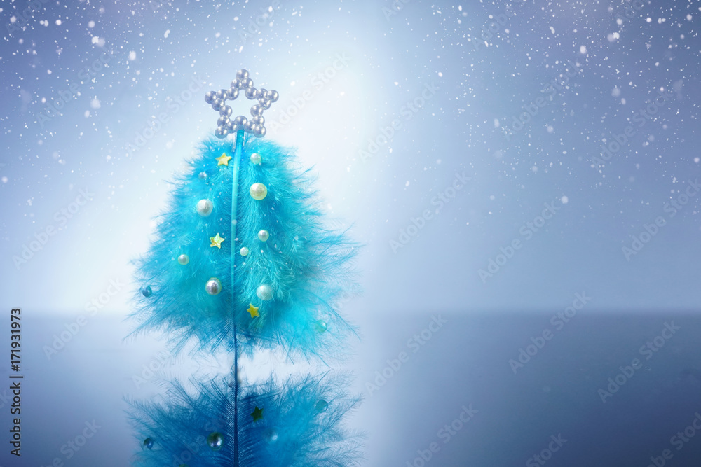 Poster creative concept for christmas and new year. beautiful christmas tree of feathers on blue and white 