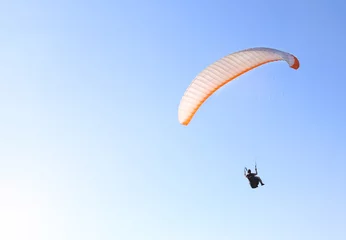 Photo sur Plexiglas Sports aériens A man is flying on a paraglider in the sky
