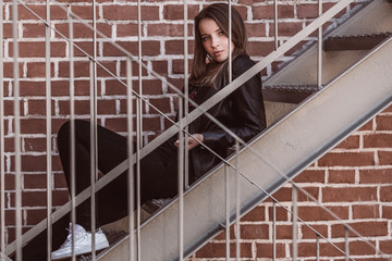 Portrait of a beautiful young woman against a brick wall background