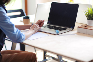 Young woman sitting at office table with laptop. Young woman. Laptop