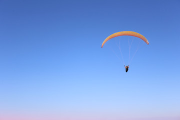 A man is flying on a paraglider in the sky