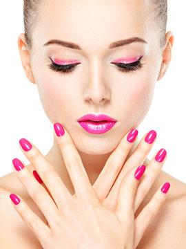 eautiful woman face with pink makeup of eyes and nails.