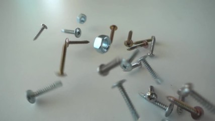 Screws falling in slow motion - Powered by Adobe