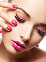  face of a beautiful  girl with pink eye makeup, lips and bright pink  nails.
