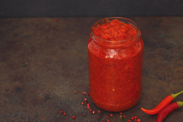 Homemade ajvar, delicious product of roasted red pepper, in jar. Macro, selective focus. blank space