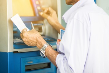 Men are pressing money from the ATM.