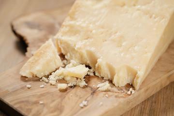 pieces of hard parmesan cheese on olive board