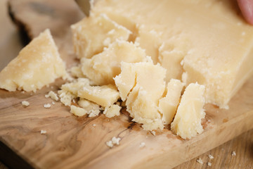 pieces of hard parmesan cheese on olive board