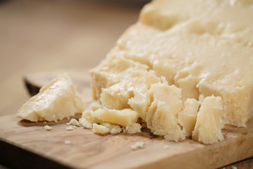 pieces of hard parmesan cheese on olive board