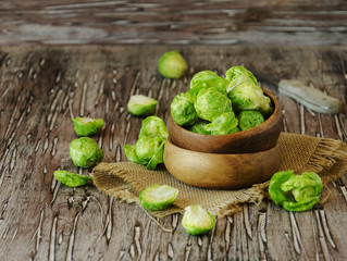 Green raw Brussels sprouts in wooden bowl , selective focus