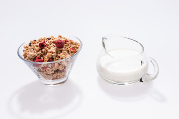 Muesli with red fruits and milk in glass isolated