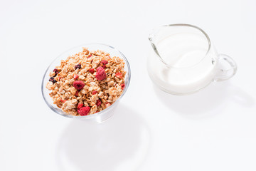 Obraz na płótnie Canvas Muesli with red fruits and milk in glass isolated
