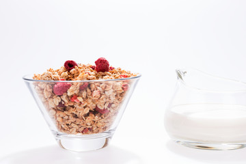 Muesli with red fruits and milk in glass isolated