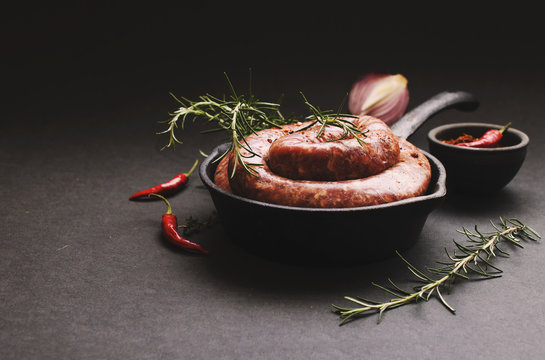 raw beef sausages on a cast-iron pan, selective focus