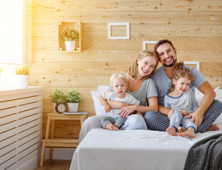  happy family mother father and children daughter and son in bed