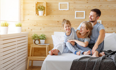 happy family mother, father and child   laughs in bed