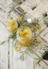 Obraz na płótnie Canvas orange marmalade in small glass jars with rosemary, selective focus