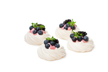 Mini  Pavlova meringue nests with berries and thyme isolated on white