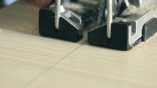 electric jigsaw cuts laminated board