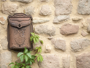 antique brown rusty mailbox on a stone made wall