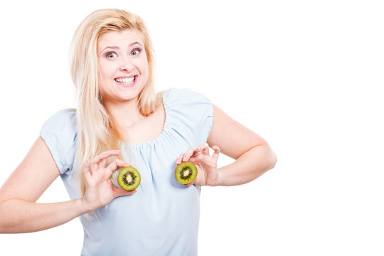 Woman holding green kiwi on breast