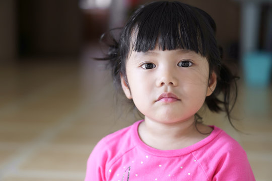 Closeup Asian Children Cute Or Kid Girl And Big Eye With Look At The Face And Displeased Or Frown Angry At Home With Space