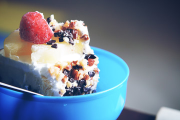 vintage blue ice-cream cake with nut and chocolate topper is strawberry and pineapple in blue cup for sweet dessert and birthday with space