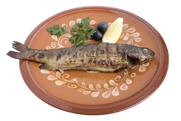 Baked carp on a clay plate.