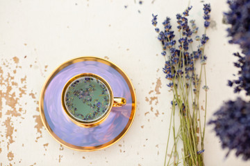 Close-up photo of freshly prepared hot cup of lavender loose tea placed on a wooden table