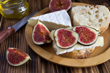 Sandwiches with cheese and figs on the brown cutting board