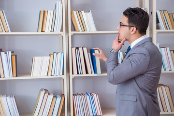 Businessman student reading a book studying in library