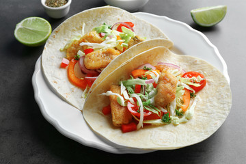 Plate with tasty fish tacos on gray table