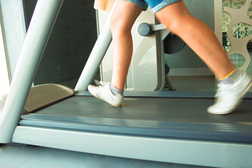 Fitness girl running on treadmill. Woman in gym