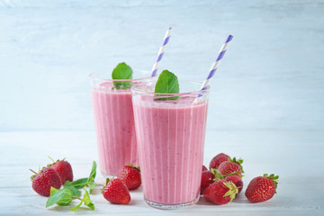 Glasses of fresh strawberry smoothie on table